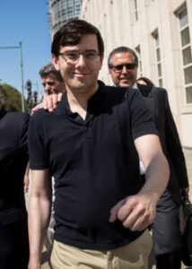 Martin Shkreli leaving court in a black T-shirt and khaki trousers