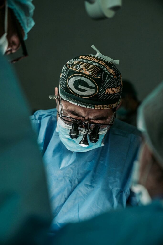 Surgeon in blue gown operating on a patient