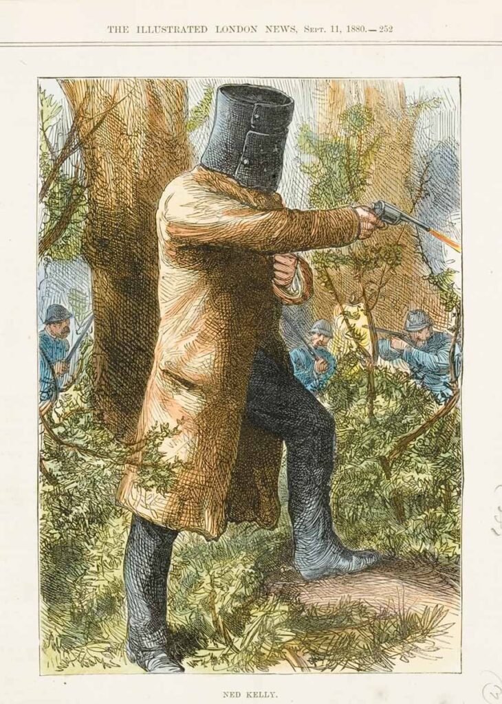 Ned Kelly dressed in his famous armour emerging from the bush with his guns drawn.